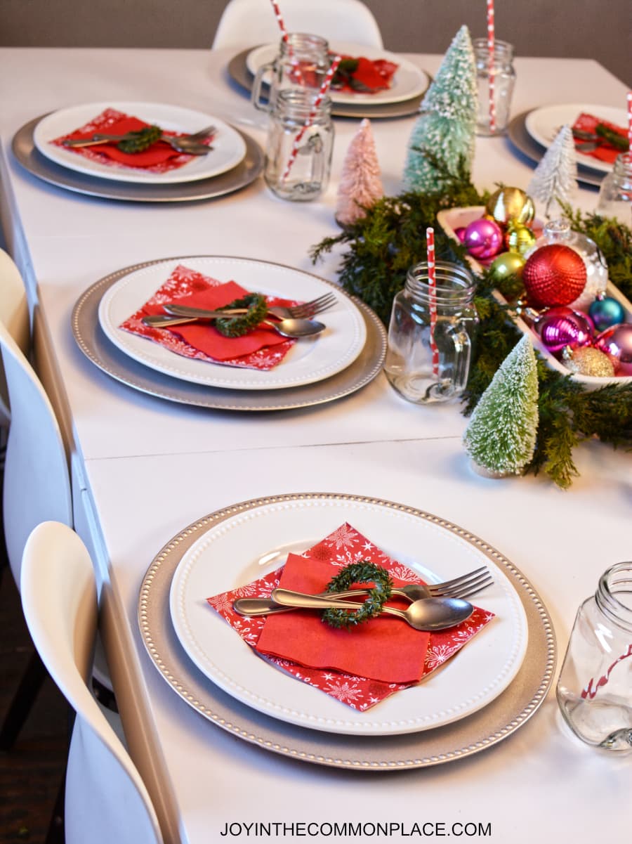 Bright & colorful tablescape with spruce tree branches and ornaments